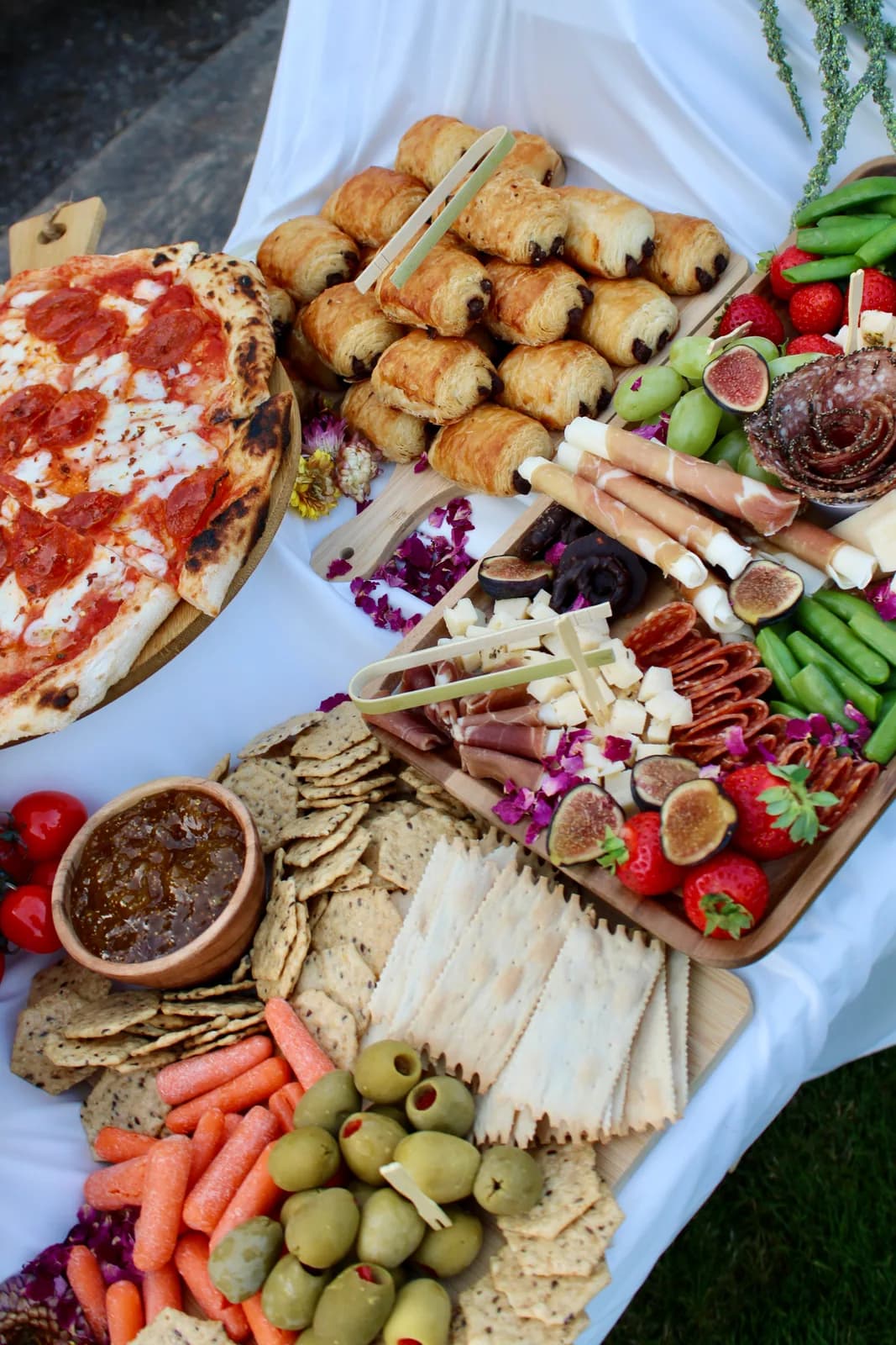 Overhead view of a Forno Via grazing table with pizza, charcuterie, cheeses, fruit, vegetables, and breads