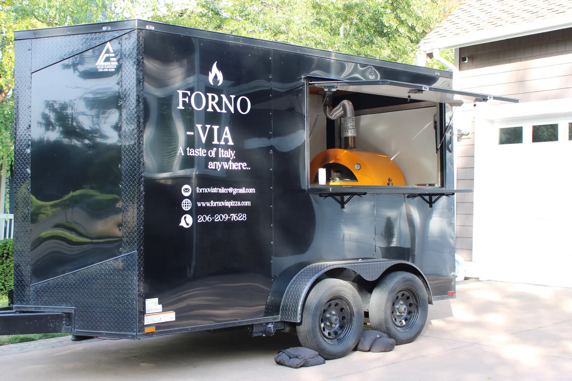 Forno Via mobile wood-fired pizza trailer set up for an outdoor event